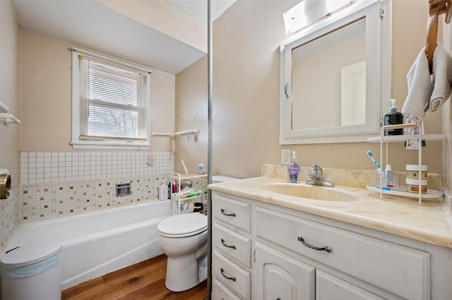 bathroom featuring hardwood / wood-style flooring, vanity, a washtub, and toilet