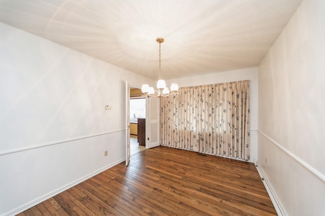 unfurnished dining area featuring a baseboard radiator, dark wood-type flooring, and a notable chandelier