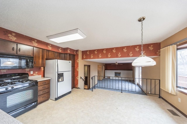 kitchen with hanging light fixtures, dark brown cabinetry, black appliances, a textured ceiling, and light colored carpet