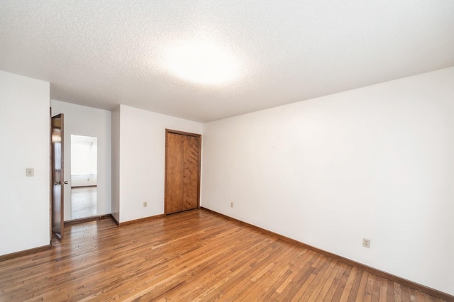 spare room with hardwood / wood-style floors and a textured ceiling