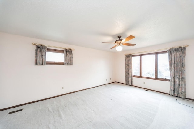 empty room featuring light carpet, plenty of natural light, and ceiling fan