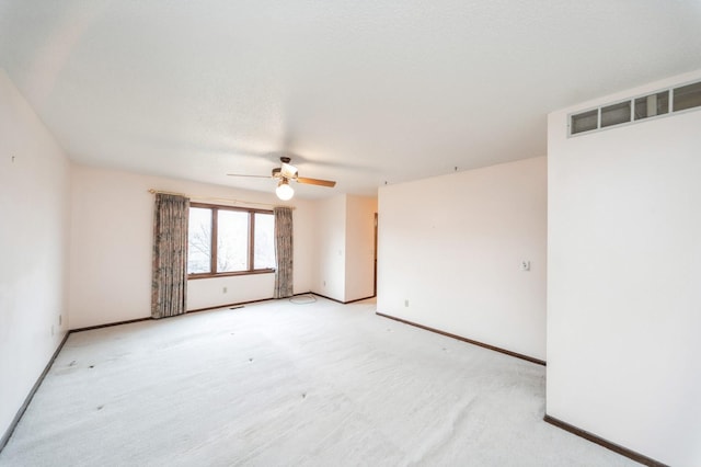 carpeted spare room featuring ceiling fan