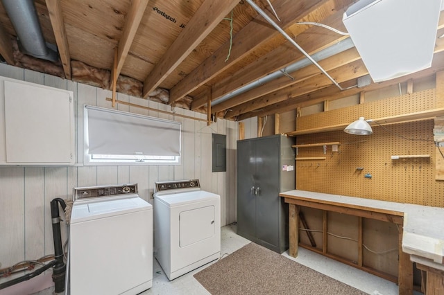 washroom with wood walls, separate washer and dryer, electric panel, and a workshop area