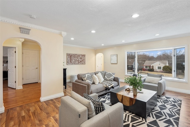 living room with crown molding, hardwood / wood-style flooring, and a textured ceiling