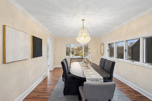 dining room with dark hardwood / wood-style flooring, ornamental molding, a textured ceiling, and an inviting chandelier