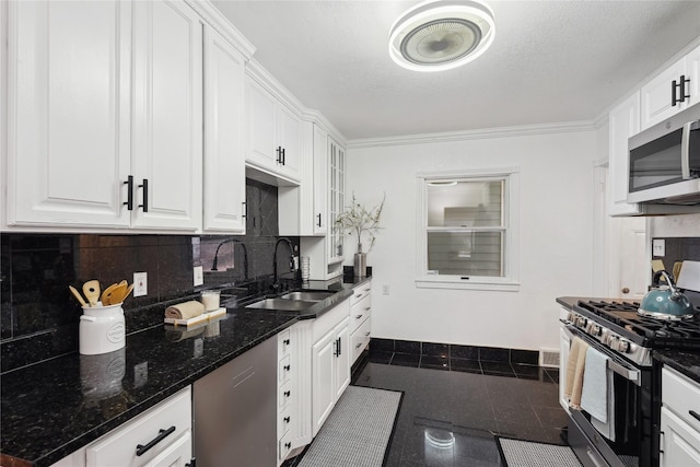 kitchen featuring stainless steel appliances, sink, dark stone counters, and white cabinets