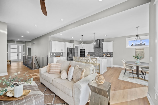 living room featuring a notable chandelier and light wood-type flooring