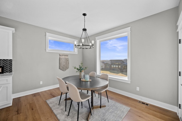 dining room featuring an inviting chandelier and light hardwood / wood-style flooring