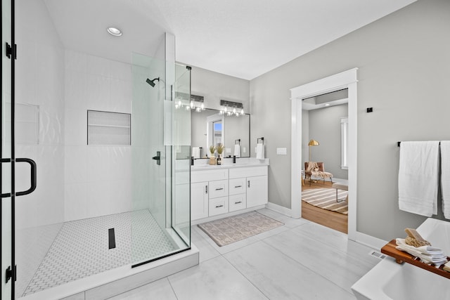 bathroom with tile patterned flooring, a shower stall, vanity, and baseboards