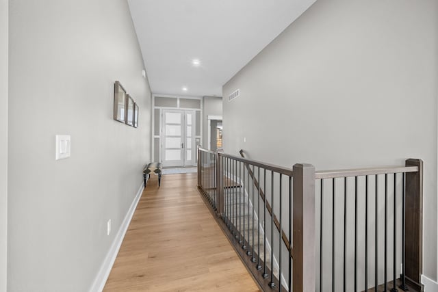 hallway with light hardwood / wood-style floors