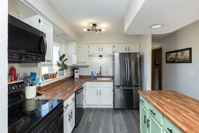 kitchen with white cabinets, a sink, wood counters, and black appliances