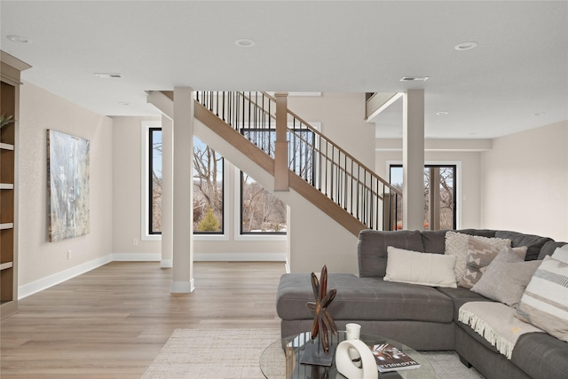 living room featuring ornate columns and light wood-type flooring