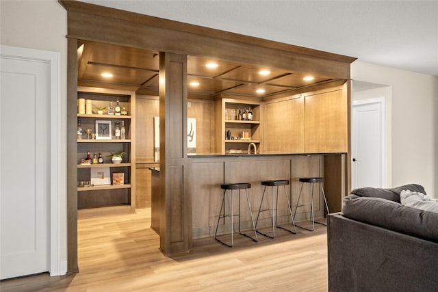 bar with sink and light wood-type flooring