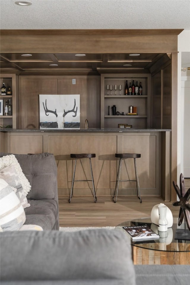 bar with wood-type flooring, sink, and built in features