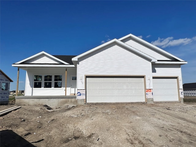 ranch-style house with a porch, a garage, and driveway