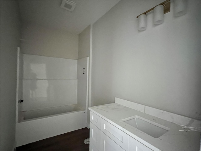 full bathroom featuring wood finished floors, vanity, and shower / tub combination
