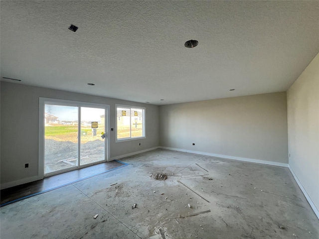 empty room featuring a textured ceiling and baseboards