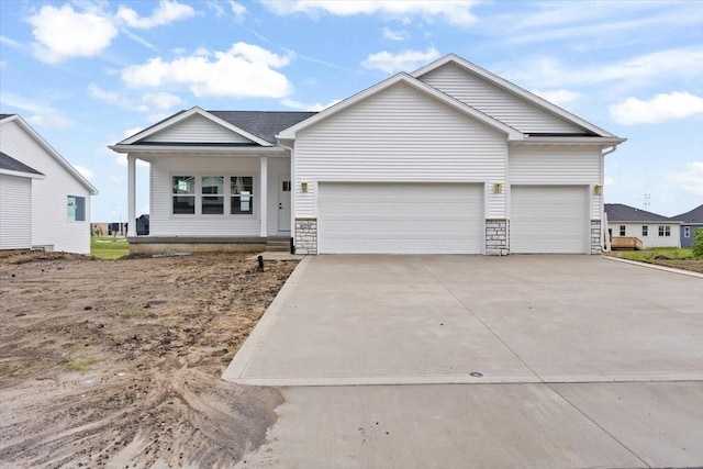 625 NW Georgetown Dr, Waukee, IA 50263 - view of front of home featuring an attached garage, concrete driveway, a porch, and stone siding