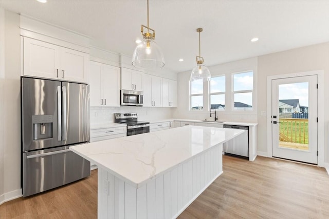 625 NW Georgetown Dr, Waukee, IA 50263 - kitchen with stainless steel appliances, light wood-style flooring, white cabinets, recessed lighting, and a kitchen island