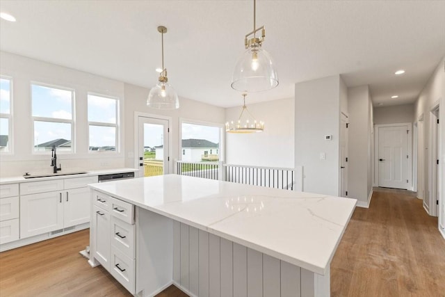 625 NW Georgetown Dr, Waukee, IA 50263 - kitchen with a center island, light wood-type flooring, white cabinets, recessed lighting, and hanging light fixtures
