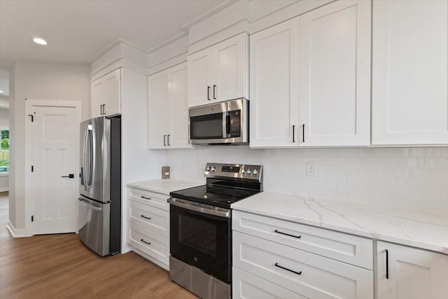 625 NW Georgetown Dr, Waukee, IA 50263 - kitchen with stainless steel appliances, white cabinetry, light wood-style floors, tasteful backsplash, and recessed lighting