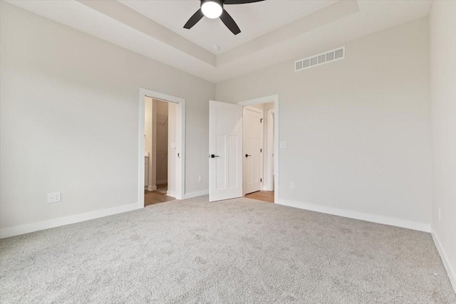 625 NW Georgetown Dr, Waukee, IA 50263 - unfurnished bedroom with carpet, a tray ceiling, ceiling fan, and a spacious closet