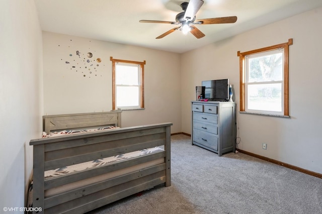 carpeted bedroom with multiple windows and ceiling fan