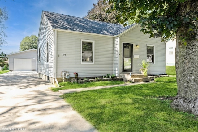 view of front of home with a garage, an outbuilding, and a front lawn