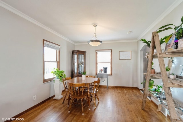 dining area with hardwood / wood-style flooring, ornamental molding, and plenty of natural light