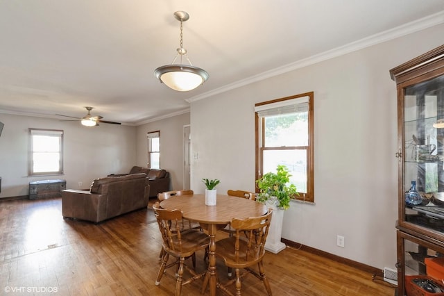 dining room with hardwood / wood-style floors, ornamental molding, and ceiling fan