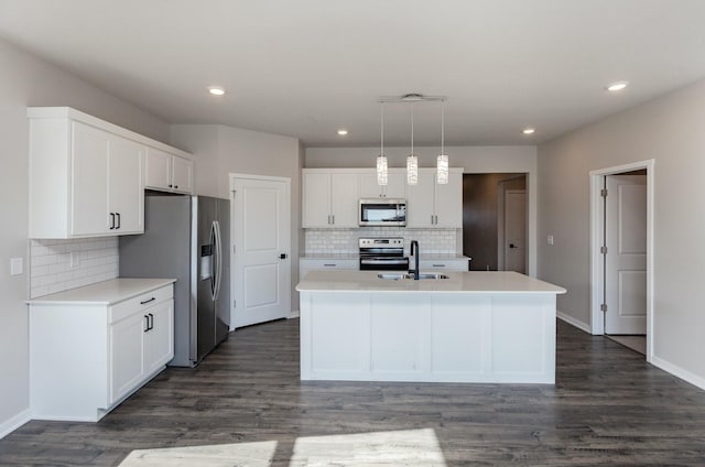 kitchen with sink, decorative light fixtures, a center island with sink, appliances with stainless steel finishes, and white cabinets