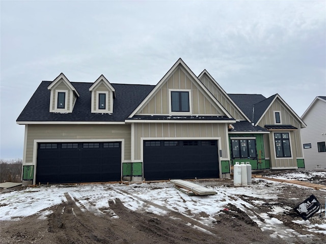 view of front of property with a garage, roof with shingles, and board and batten siding