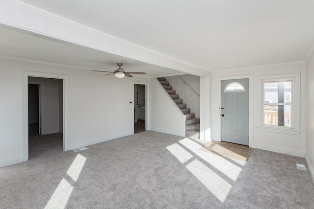 entryway featuring crown molding and light carpet