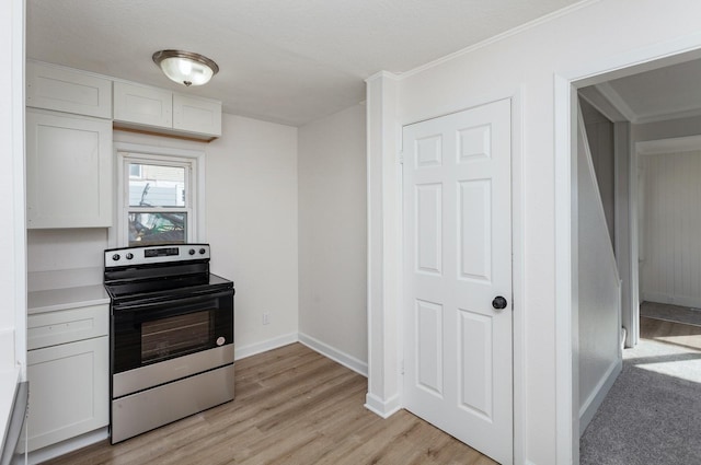 kitchen with electric stove, light hardwood / wood-style floors, and white cabinets