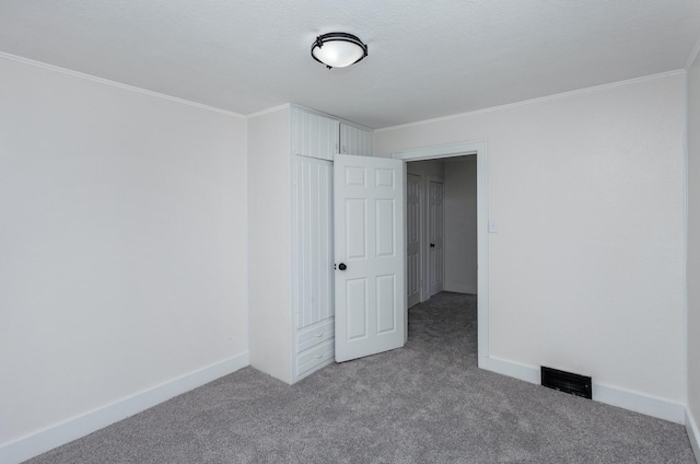 unfurnished bedroom with crown molding, carpet flooring, and a closet