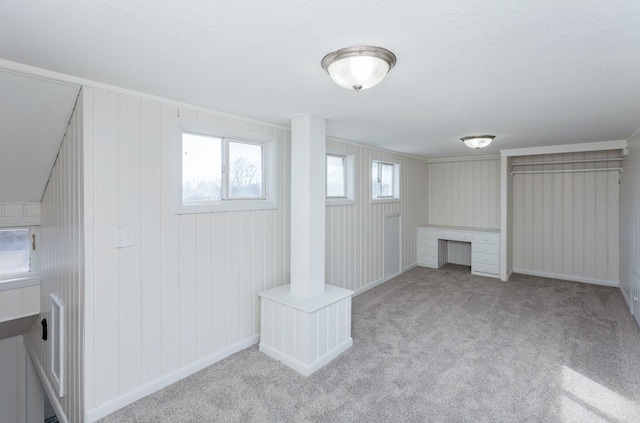 additional living space featuring light carpet and built in desk