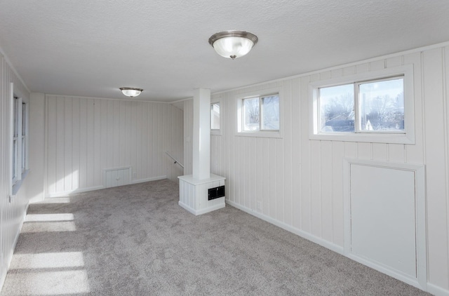 basement with light colored carpet and a textured ceiling