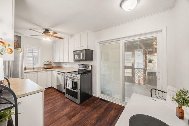 kitchen featuring sink, ceiling fan, stainless steel appliances, dark hardwood / wood-style floors, and white cabinets