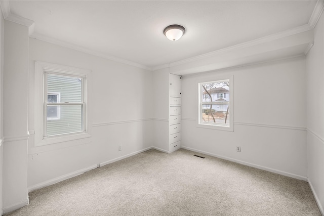 carpeted spare room featuring crown molding