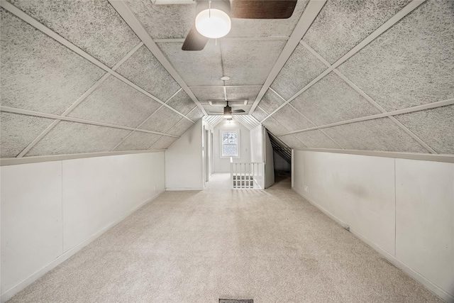 additional living space with ceiling fan, vaulted ceiling, and light carpet