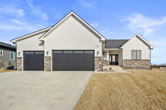 view of front of house featuring a garage and central AC