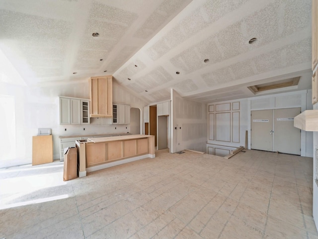 kitchen featuring vaulted ceiling and light brown cabinets