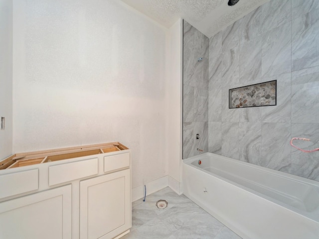 bathroom with tiled shower / bath combo and a textured ceiling