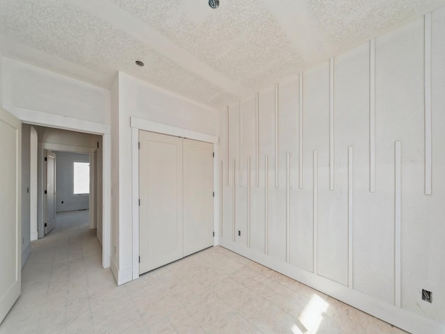 unfurnished bedroom featuring a closet and a textured ceiling