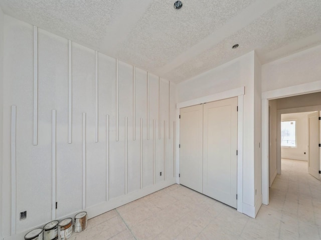 unfurnished bedroom with a textured ceiling and a closet