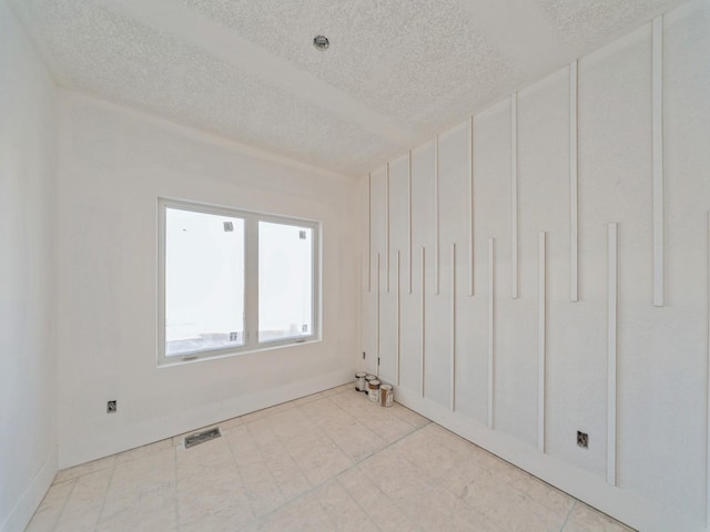 unfurnished room with a textured ceiling