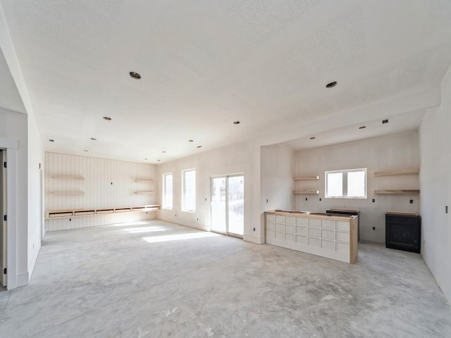 unfurnished living room featuring a wealth of natural light and a textured ceiling