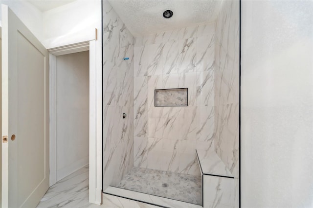 bathroom featuring tiled shower and a textured ceiling