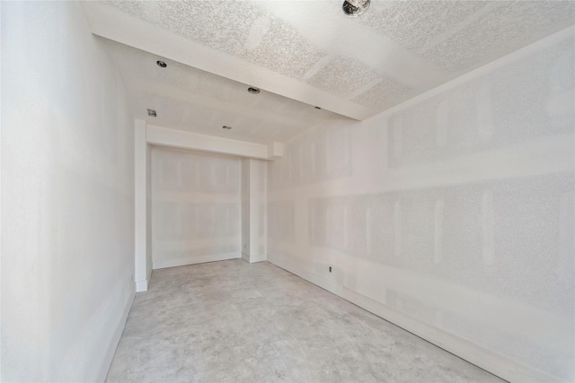 spare room with concrete floors and a textured ceiling