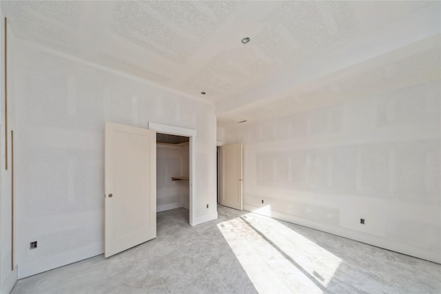 unfurnished bedroom featuring a spacious closet and a textured ceiling